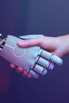 Um braço de um robot a apertar a mão de um humano